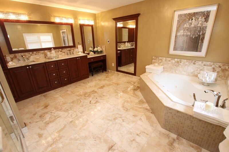 Luxurious bathroom featuring a spacious layout, elegant dark wood cabinetry, marble flooring, a modern soaking tub, and stylish lighting, showcasing Superior Bath's custom renovation craftsmanship.