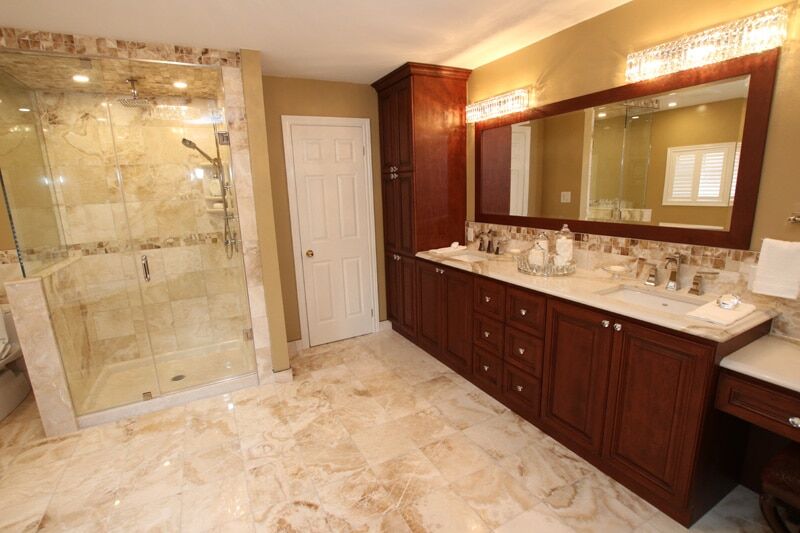 Modern bathroom renovation featuring a glass shower enclosure, elegant wooden cabinetry, and a stylish vanity with decorative accessories, showcasing Superior Bath's craftsmanship.