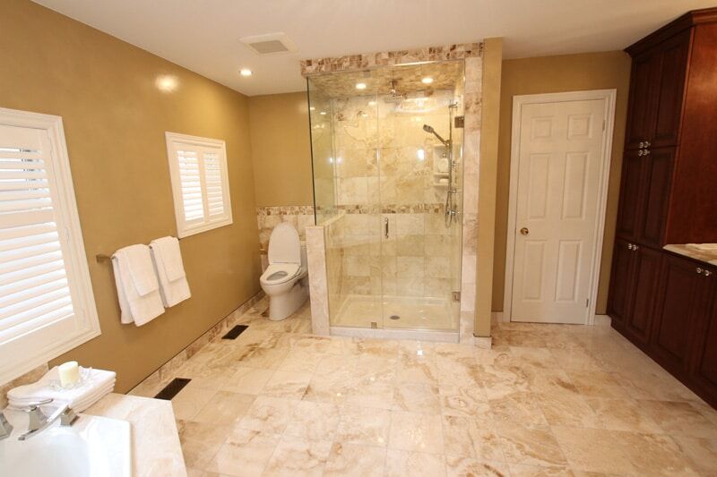 Modern bathroom renovation featuring a glass shower, elegant marble flooring, and stylish cabinetry by Superior Bath.