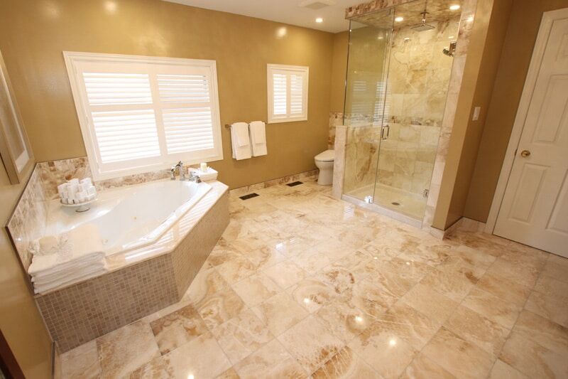 Luxurious bathroom featuring a freestanding tub, glass shower, marble flooring, and elegant fixtures, showcasing Superior Bath's custom renovation work.