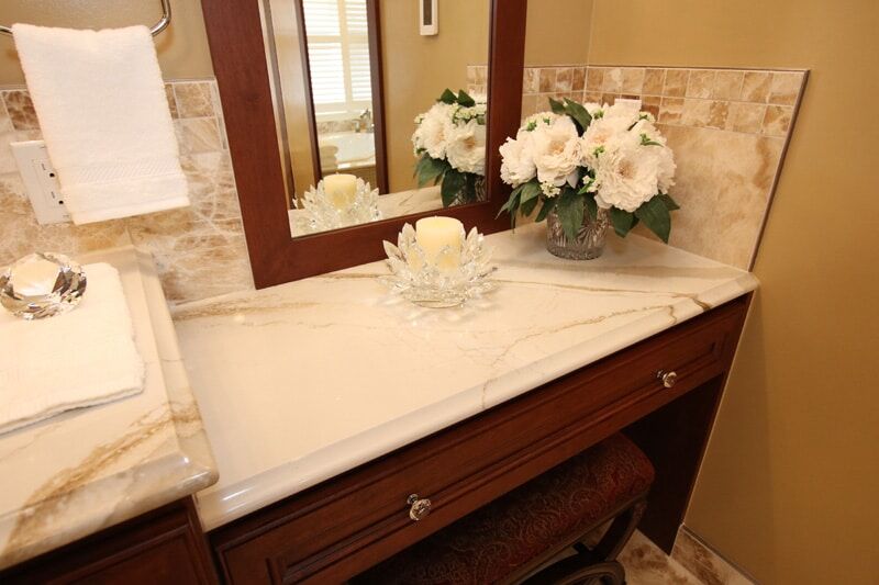 Elegant bathroom vanity with marble countertop, decorative flowers, and a candle, showcasing Superior Bath's custom renovation craftsmanship.