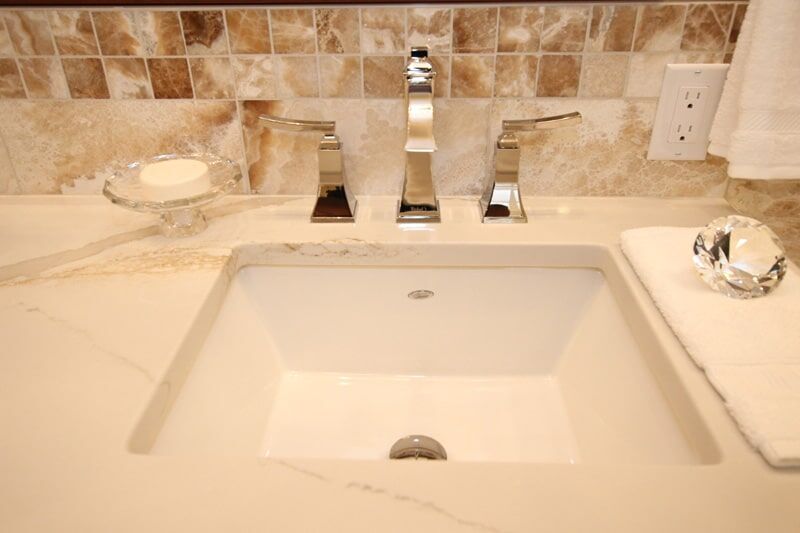 Modern bathroom sink with elegant chrome faucets, marble countertop, and decorative soap dish, showcasing Superior Bath's custom renovation style.