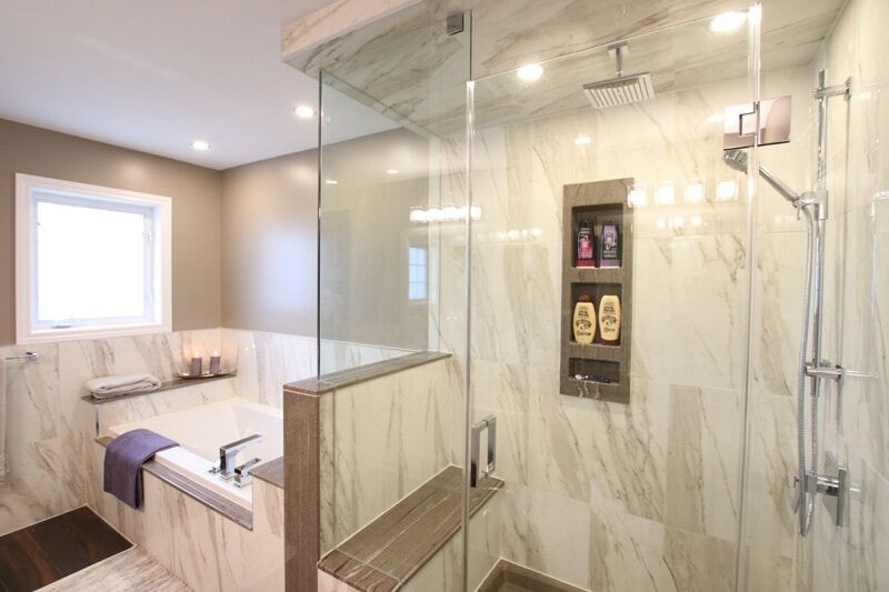 Modern bathroom renovation featuring a glass shower enclosure, freestanding tub, marble tiles, and stylish fixtures by Superior Bath.