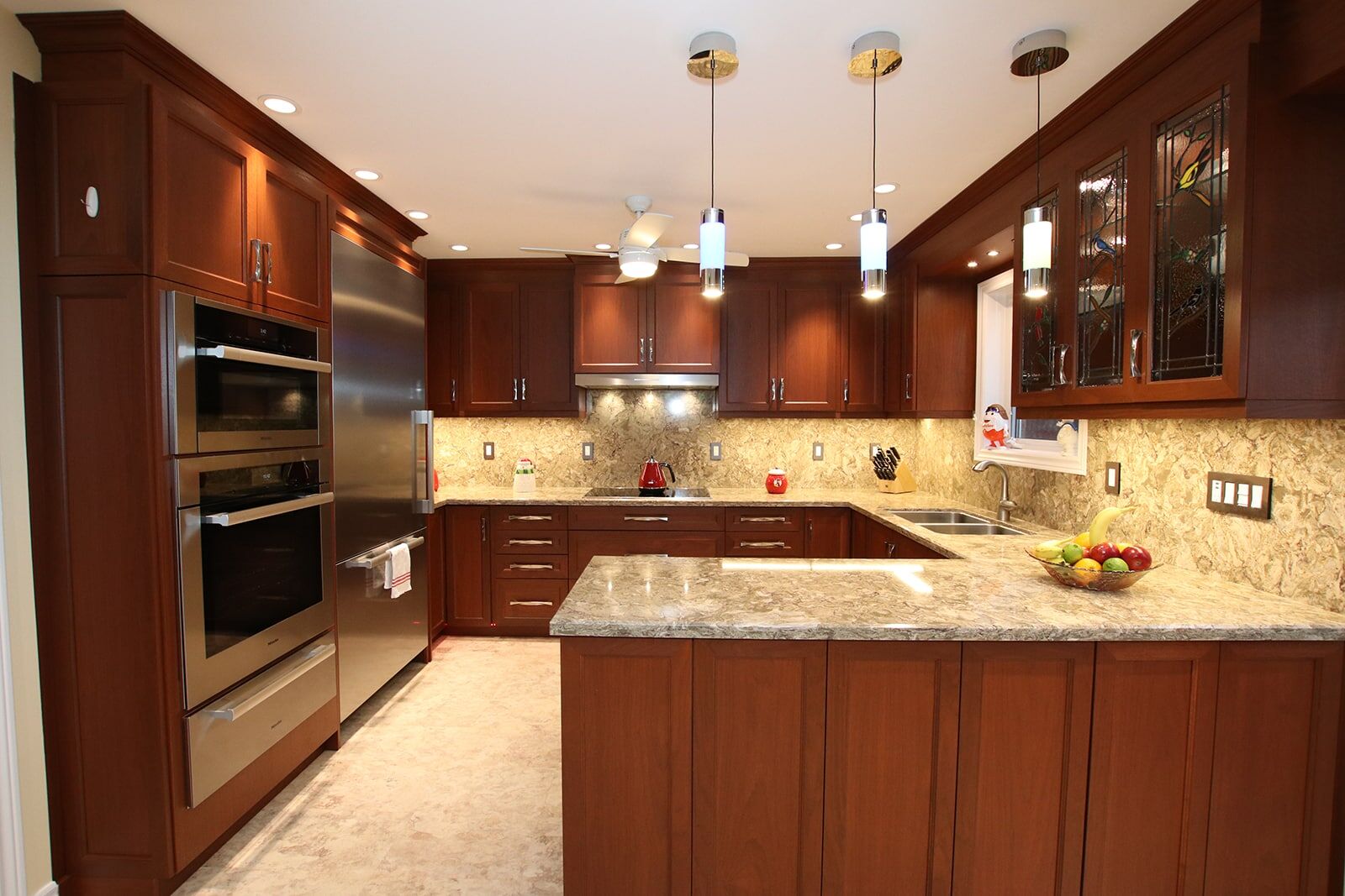 Modern kitchen with dark wood cabinetry, stainless steel appliances, granite countertops, and pendant lighting, showcasing Superior Bath's renovation expertise.
