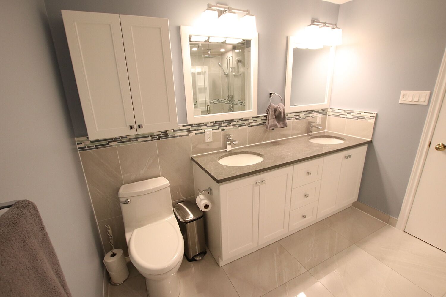 Modern bathroom design featuring dual sinks, white cabinetry, and a glass-enclosed shower, showcasing Superior Bath's custom renovation work.