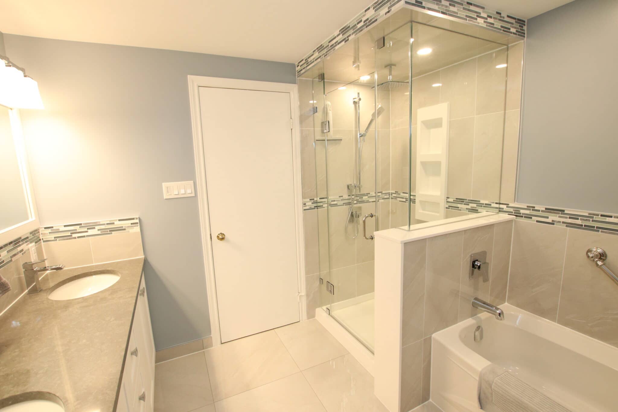 Modern bathroom interior featuring a glass shower enclosure, double sink vanity with granite countertop, and elegant tile accents, showcasing Superior Bath's custom renovation work.