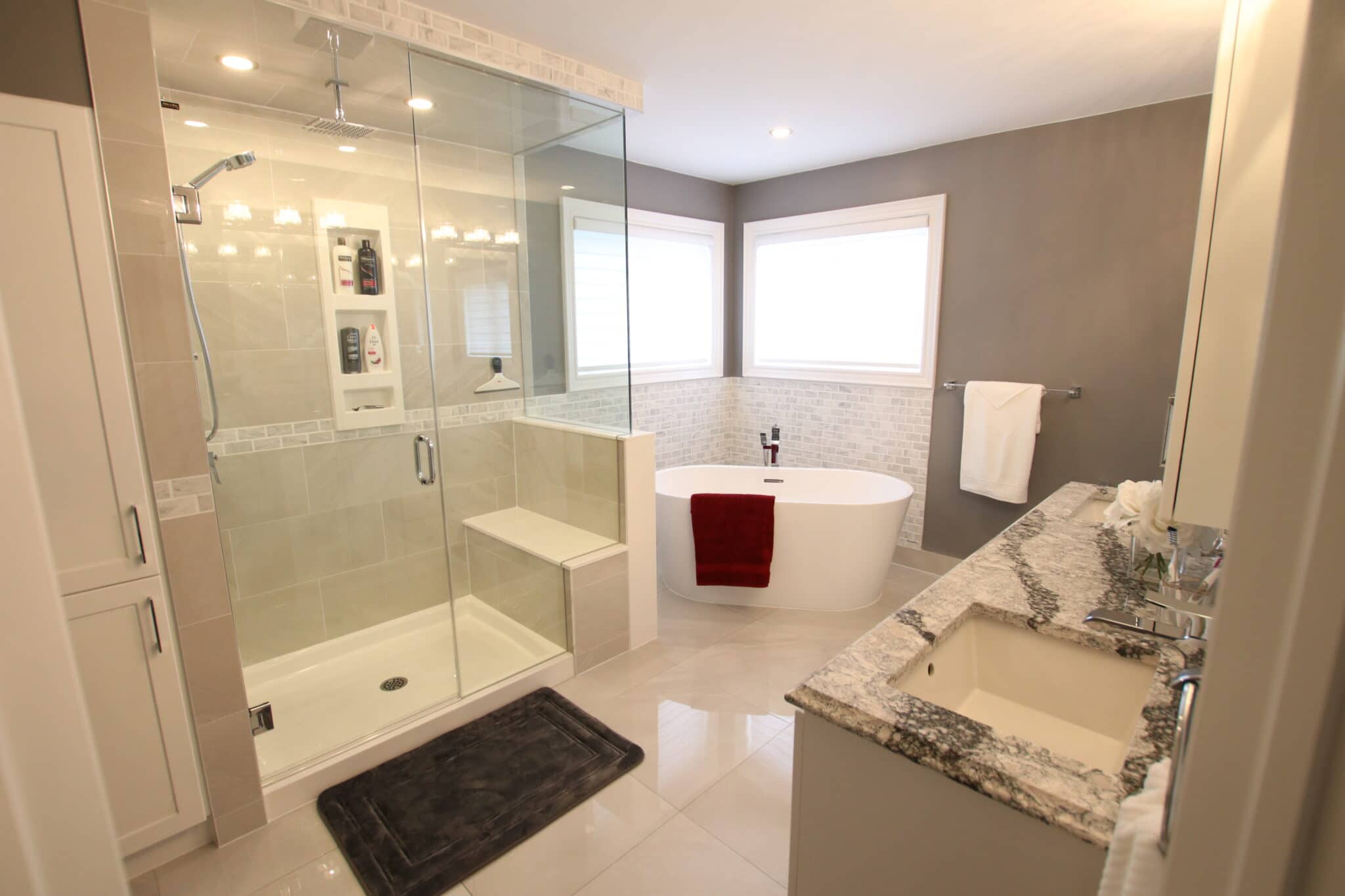 Modern bathroom with glass shower, freestanding tub, and sleek granite countertop, showcasing Superior Bath's custom renovation style.