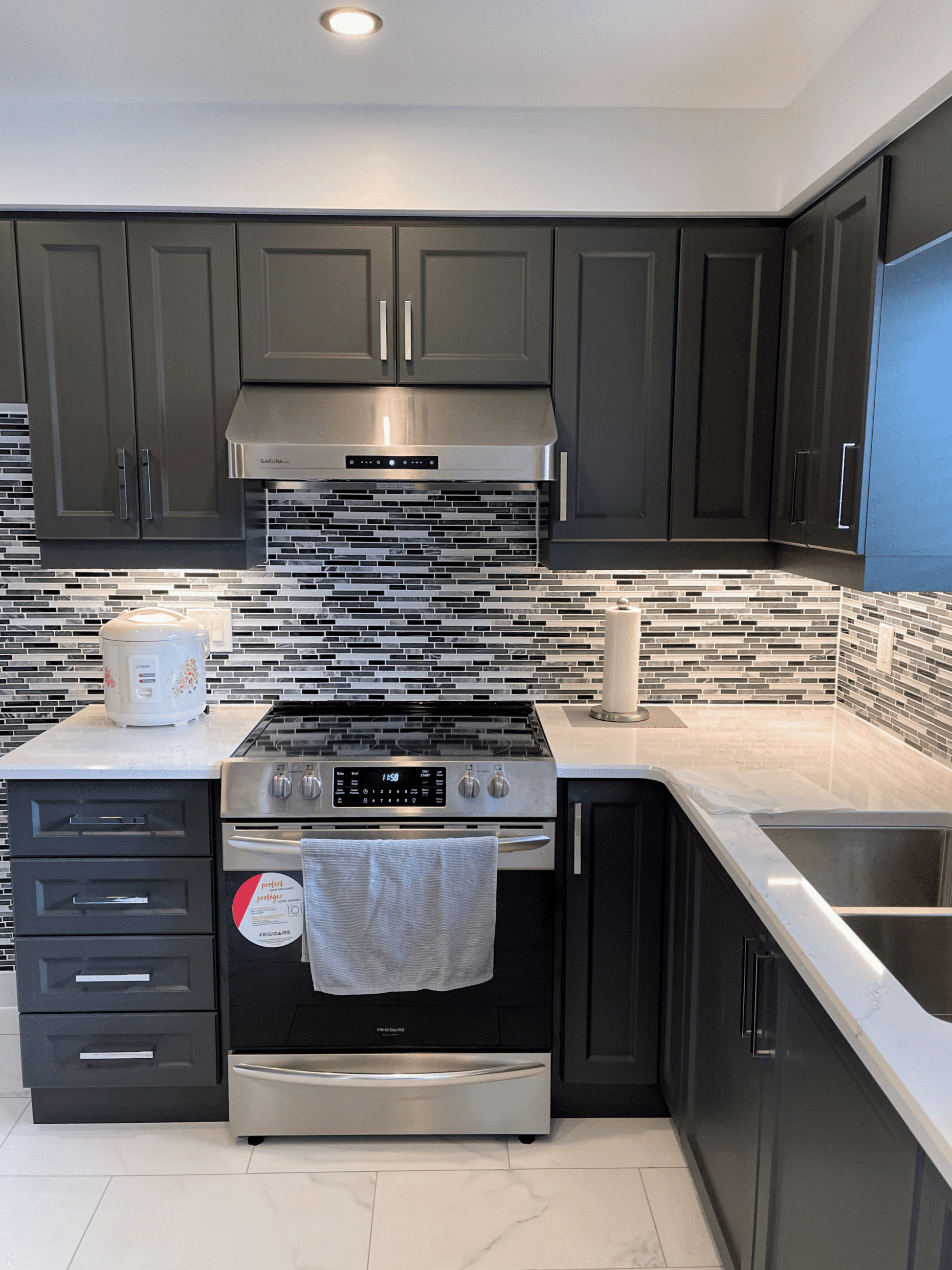 Modern kitchen featuring dark cabinetry, stainless steel appliances, and a stylish backsplash, showcasing Superior Bath's kitchen renovation work.