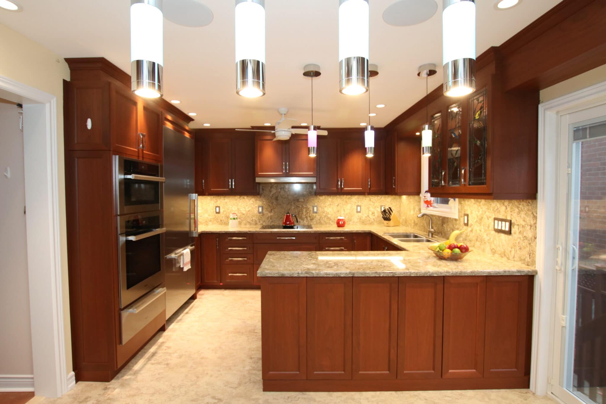Modern kitchen featuring dark wood cabinetry, granite countertops, stainless steel appliances, and stylish pendant lighting, showcasing Superior Bath's renovation expertise.