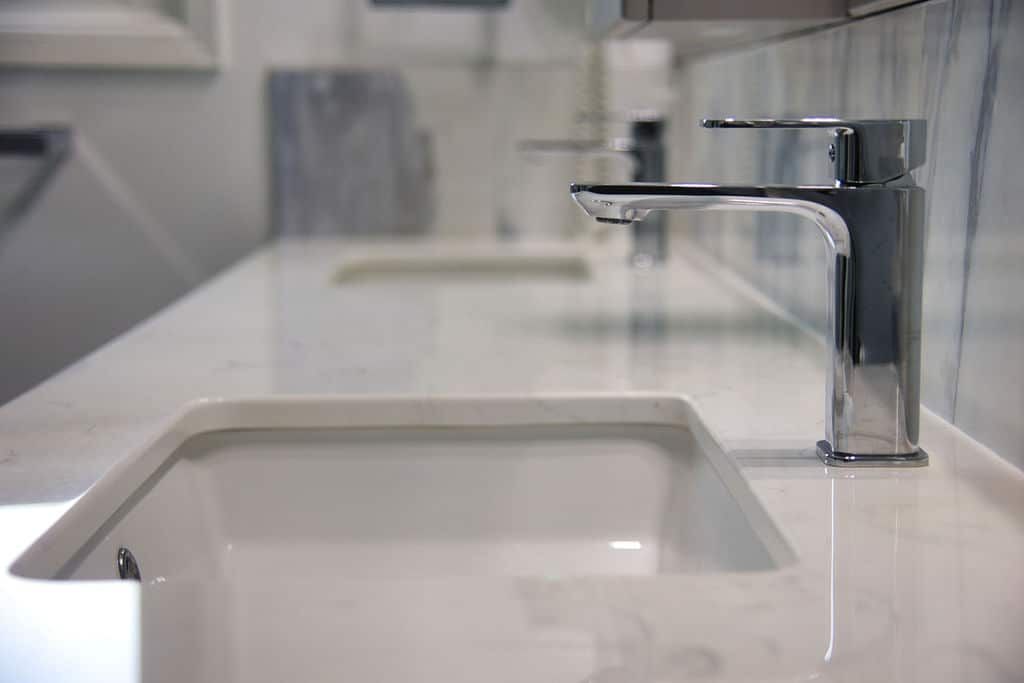 Modern bathroom sink with sleek chrome faucet on white marble countertop, showcasing Superior Bath's custom renovation craftsmanship.