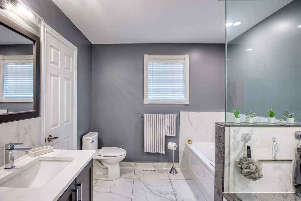 Modern bathroom renovation featuring sleek fixtures, marble accents, and a glass shower enclosure, showcasing Superior Bath's craftsmanship and design.