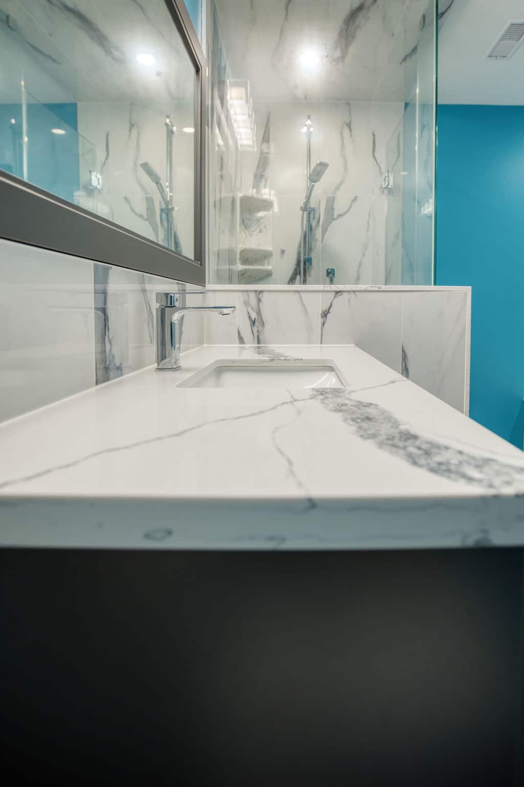 Custom bathroom countertop with marble finish, modern faucet, and glass shower enclosure, showcasing Superior Bath's renovation expertise.
