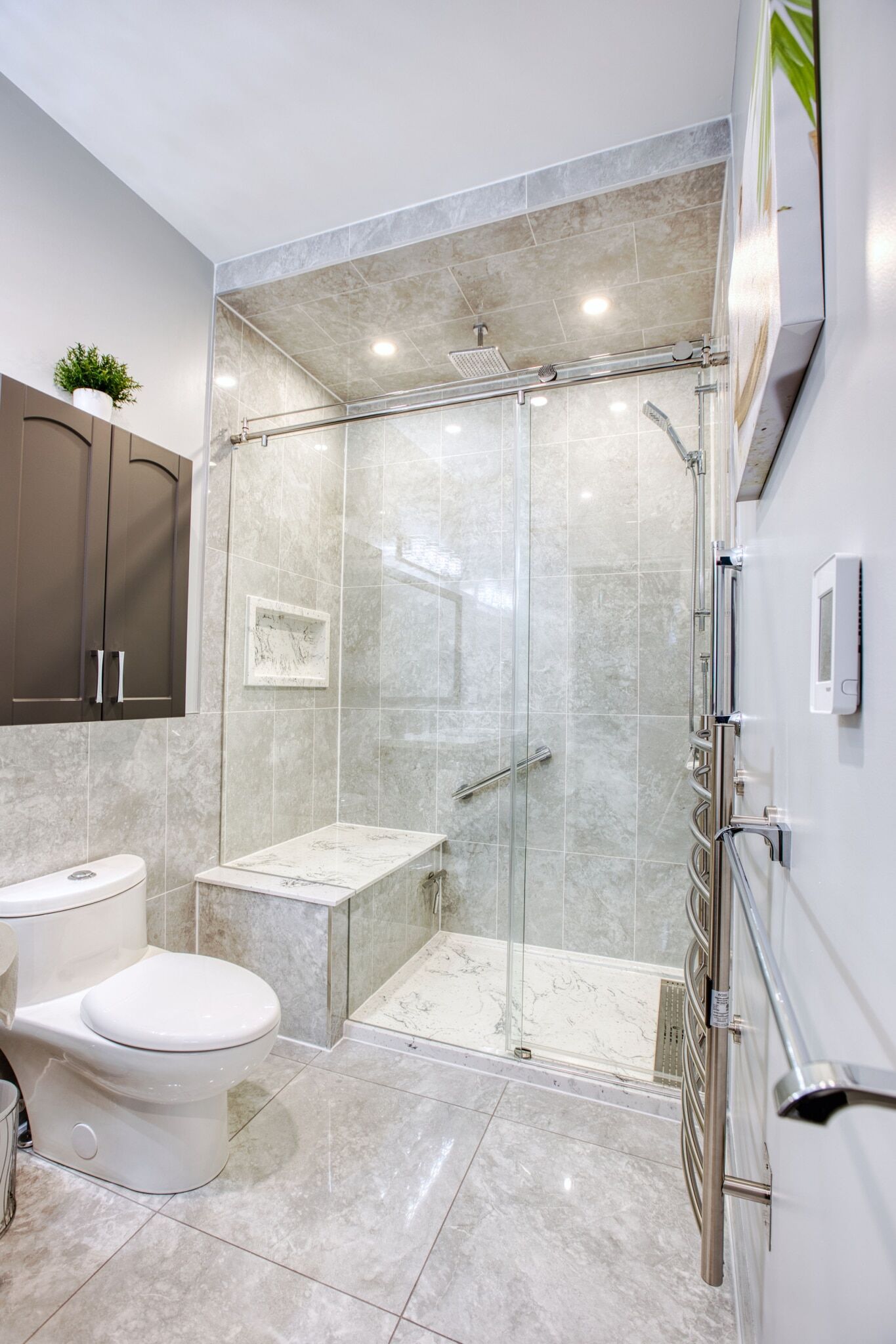 Modern bathroom renovation featuring a glass shower enclosure, marble accents, a sleek toilet, and stylish cabinetry by Superior Bath.